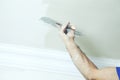 Closeup of repairman hand plastering a wall with putty knife or spatula Royalty Free Stock Photo