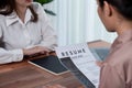 Closeup resume paper with qualifications on desk during interview. Enthusiastic