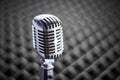 Closeup of retro condenser microphone on acoustic foam panel background