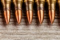 Closeup of rifle full metal jacket bullets in a row on wooden background with copy space Royalty Free Stock Photo