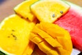 Closeup ripe juicy sliced fruits of mango and red and yellow watermelon. Sweet and colorful fruit plate Royalty Free Stock Photo