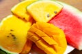 Closeup ripe juicy sliced fruits of mango and red and yellow watermelon. Sweet and colorful fruit plate Royalty Free Stock Photo