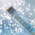 Closeup of RJ45 UTP LAN on the background of optical fibers with blurred lights Royalty Free Stock Photo