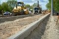 Closeup of a road reparation with machines and trees in the background.