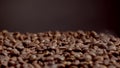 Closeup roasted coffee seeds background. Fragrant seeds pouring down on roaster. Royalty Free Stock Photo