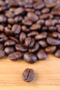 Closeup of a Robusta Roasted Coffee Bean with Coffee Beans Pile in Background Royalty Free Stock Photo