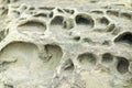Closeup rock erosion holes sea wall. Royalty Free Stock Photo