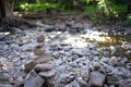 Stone cairn along peaceful forest stream Royalty Free Stock Photo