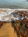 Closeup of Rocky coast. Water waves touching red rocky fungi stones. Royalty Free Stock Photo