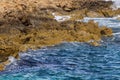 Closeup rocky sea cape among splashing waves