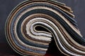 Closeup of rolled samples of upholstery leather against dark background