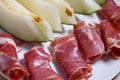 Closeup of rolled slices of cured pork ham jamon with melon Royalty Free Stock Photo