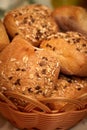 Closeup of rolls of freshly baked bread topped with grains, in a wicker basket Royalty Free Stock Photo