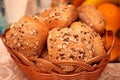 Closeup of rolls of freshly baked bread topped with grains, in a wicker basket Royalty Free Stock Photo