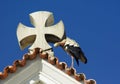 Closeup of a roof with cross and stork nest Royalty Free Stock Photo