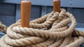 Closeup of rope around wooden pegs on sailboat.