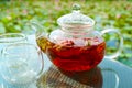 Rose tea being steeped in a teapot on garden table