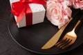 Closeup of roses, gifts, knife, and fork on a plate