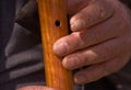 Closeup of Rough Worker Hands Playing Wooden Flute