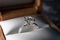 Closeup of a round diamond engagement ring in a soft ring box, blurred background Royalty Free Stock Photo