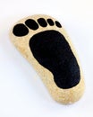 Foot print painted on pebble. Royalty Free Stock Photo