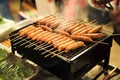 Closeup row of bbq sausages on the charcoal grill with smoke Royalty Free Stock Photo