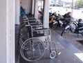 Closeup row of empty wheelchairs parking outside prepared for older people and disabled passengers