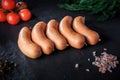 closeup row of five raw short thick sausages with dill and tomatoes Royalty Free Stock Photo