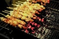 Closeup row of meat bbq on the metal grill with blurred hot charcoal on the tray in background Royalty Free Stock Photo