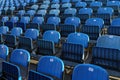 Closeup of rows of blue folded chairs at a stadium