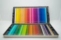 Closeup of rows of colored pencils in a case on the white surface