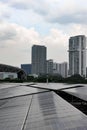 Closeup of the rows of the solar panels under the cloudy blue sky in a city