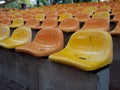 Closeup of rows of yellow and orange bleacher chairs Royalty Free Stock Photo