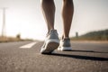 Closeup of runner shaved feet in running shoes going for a run on the road at sunrise or sunset.