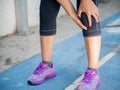 Closeup runner sport knee injury. Woman in pain while running.