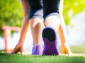 Closeup of running shoes on grass, young lady on start position and going to run in park. Royalty Free Stock Photo