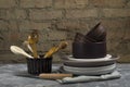 Closeup of rustic kitchenware, utensil on the table against old brick wall.Woodn spoons, clay and ceramic plates, bowls, napkin on