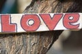 Closeup of rustic wooden love sign hooked on a tree, Peru