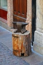 Closeup of a rusty anvil on a wooden post on the street Royalty Free Stock Photo