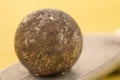 Closeup of a rusty ball bearing on a copper plate