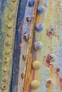 Closeup of a rusty and colorful painted metal with bolts