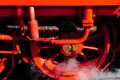 Closeup of a rusty red train wheel covered in dirt and smoke under sunlight Royalty Free Stock Photo