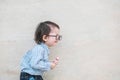 Closeup sad asian kid cry because he want something on marble stone wall textured background with copy space Royalty Free Stock Photo