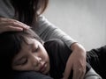 Closeup sad little boy being hugged by his mother at home. Royalty Free Stock Photo