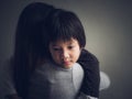 Closeup sad little boy being hugged by his mother at home Royalty Free Stock Photo