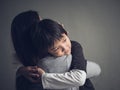Closeup sad little boy being hugged by his mother at home. Royalty Free Stock Photo