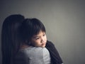 Closeup sad little boy being hugged by his mother at home Royalty Free Stock Photo