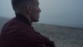 Sad man sitting sandy beach in morning. Young guy with upset face expression Royalty Free Stock Photo