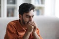 Closeup of sad middle eastern man sitting on couch at home Royalty Free Stock Photo