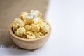 Closeup salted popcorn in round wooden bowl
